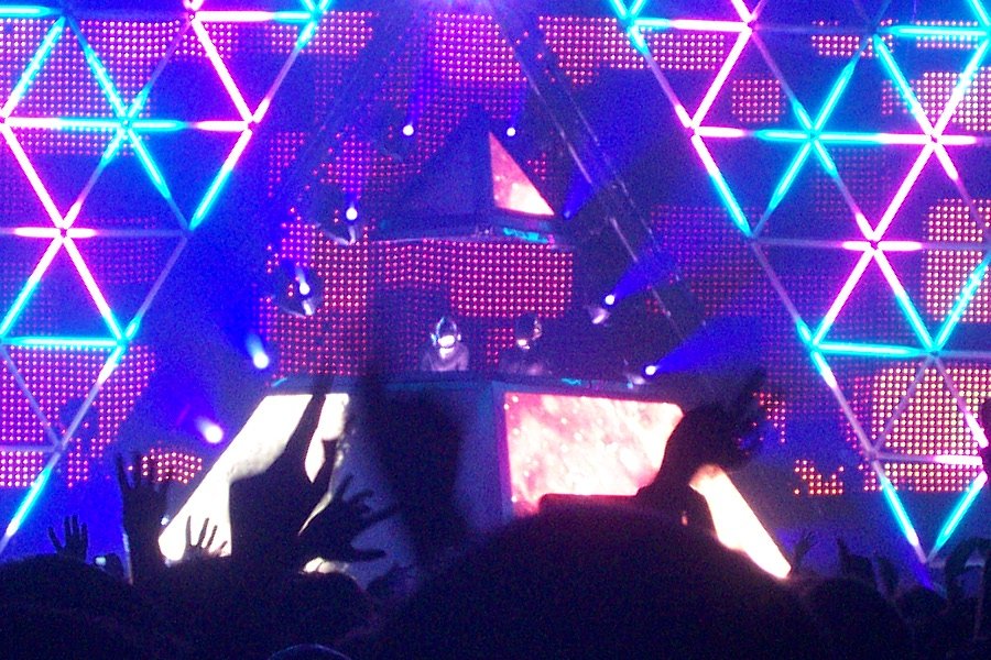 Daft Punk on stage at Bercy in Paris inside a lit pyramid with a large LED wall behind them