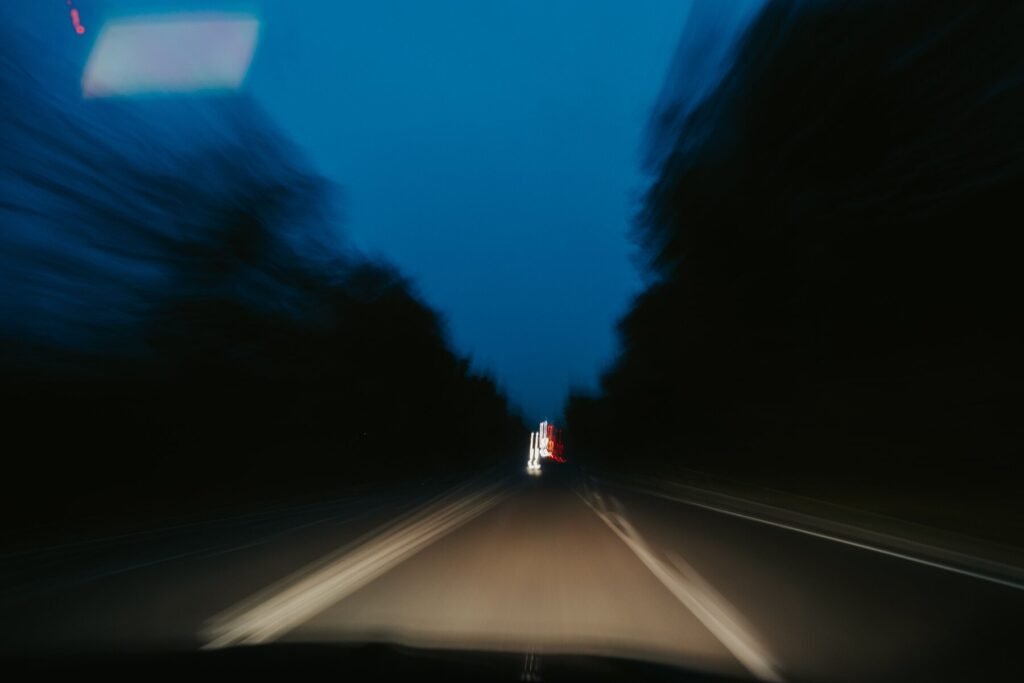 Blurred view of a highway at night from inside a moving car, headlights and tail lights streaking