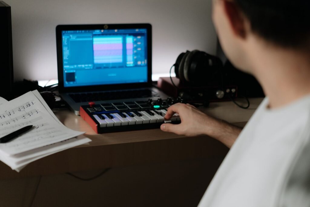 Musician playing a keyboard synthesizer in a home studio